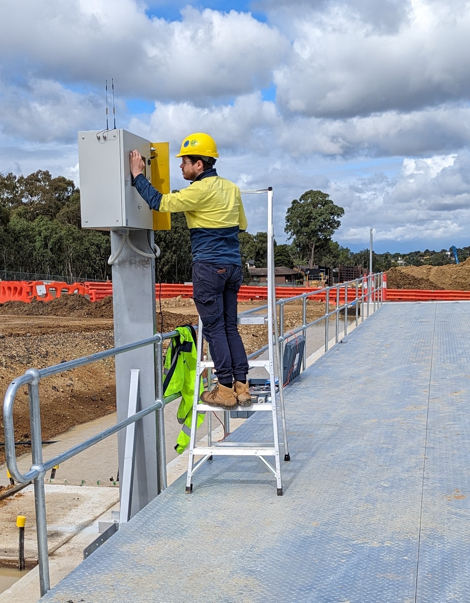 Technician installing a Startek weighbridge kiosk beside a weighbridge platform